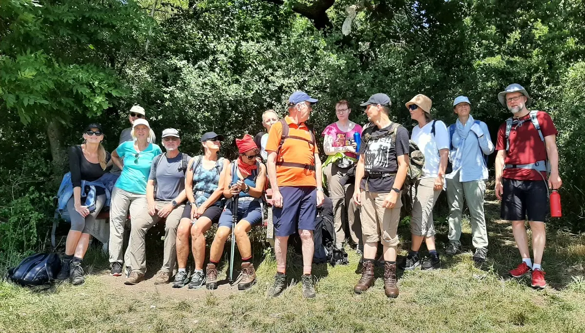 Ein Gruppenfoto von 13 Personen in Wanderkleidung vor einem Waldrand | © Andreas Spieß